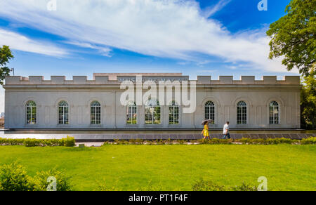 Macau, China - Juli 11, 2014: ein Mann und eine Frau in einem gelben Kleid mit einem Regenschirm sind vor dem Museum von Macau, in der berühmten... Stockfoto