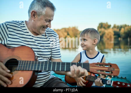 Großvater lehre Enkel Gitarre spielen Stockfoto