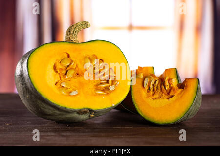 Gruppe von Hälfte zwei Scheiben frischen Blau Grau Kürbis Nagy dobosi Sorte mit seidenen Vorhängen hinter Stockfoto