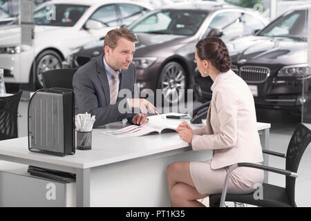 Bei der Kfz-Händler, Verkäufer, im Gespräch mit Kunden Stockfoto