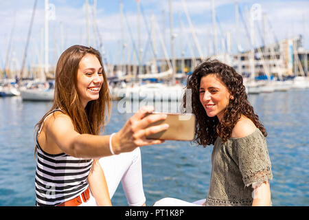 Zwei glückliche weibliche Freunde eine selfie an einem Jachthafen Stockfoto