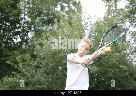 Porträt der blonde Junge Tennis spielen. Stockfoto