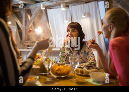 Gerne weibliche Freunde zusammen Abendessen zu Hause in Stockfoto