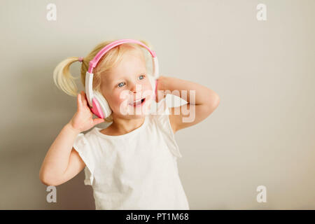 Portrait von kleinen Mädchen tanzen Musik hören mit Kopfhörern Stockfoto