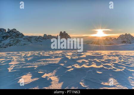 Plätzwiese/Langlauftag gemütlich, Dolomiten, Provinz Bozen, Südtirol, Italien, Muster im Wind - erodiert Schnee, im Hintergrund die aufgehende Sonne und die berühmten Gipfel der Drei Zinnen von Lavaredo Stockfoto