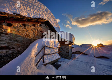 Sonnenuntergang auf der Alpe Prabello, einer kleinen Gruppe von Hütten zerquetscht durch das Gewicht der Schnee im Winter, Valmalenco, Valtellina Lombardei, Italien Europa Stockfoto