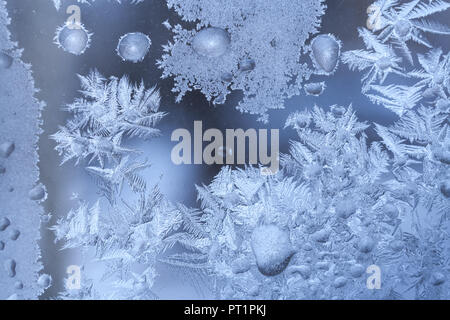 Close-up frosty Muster der Schneeflocken und große gefrorene Wassertropfen auf den Winter Fenster. Stockfoto