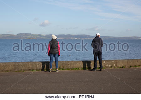 Edinburgh, Vereinigtes Königreich, 5. Oktober, 2018. Menschen mit Blick auf die Forth Estuary genießen das sonnige Wetter mit blauem Himmel in Cramond Promenade. Quelle: Craig Brown/Alamy Leben Nachrichten. Stockfoto