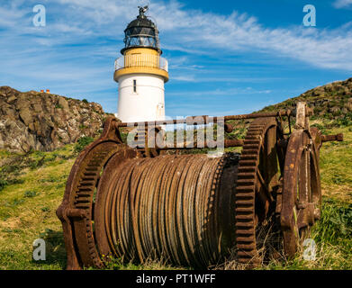 Fidra Insel, Erhabene, Schottland, Vereinigtes Königreich, 5. Oktober 2018. Fidra Leuchtturm, ein deaktivierter Stevenson Leuchtturm an einem sonnigen Tag mit Cloud Streifen und blauer Himmel. Einen rostigen Winde mit Kabel ist im Vordergrund. Stockfoto