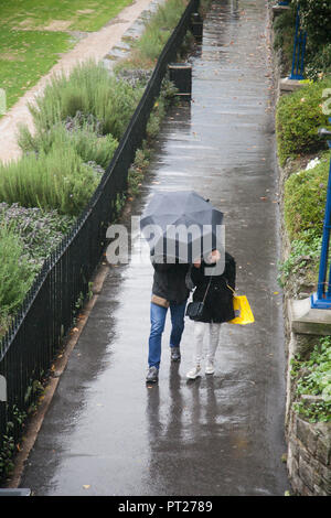 London, Großbritannien. 6. Oktober 2018. Menschen Schutz unter Sonnenschirmen in der Nähe des Tower von London, die durch Sturm Leslie Credit: Amer ghazzal/Alamy leben Nachrichten Stockfoto