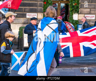 Holyrood Edinburgh, Edinburgh, Schottland, Vereinigtes Königreich, 6. Oktober 2018. Alle unter einem Banner (auob) schottischen März und Rally für Unabhängigkeit, mit Unterstützern auf der Royal Mile, dem Holyrood Park für eine Rallye. AOUB ist ein pro-unabhängigkeit Kampagne für deren Ziel ist es, in regelmäßigen Abständen zu März bis Schottland Unabhängigkeit erreicht. Pro Union Anhänger auf der Royal Mile wave Union Jacks als Unabhängigkeit unterstützer Spaziergänge Vergangenheit mit einer St Andrews Kreuz schottische Flagge über seine Schultern und ein Kind trägt ein saltire Flagge drapiert Stockfoto