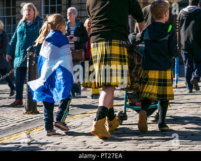 Holyrood Edinburgh, Edinburgh, Schottland, Vereinigtes Königreich, 6. Oktober 2018. Alle unter einem Banner (auob) schottischen März und Rally für Unabhängigkeit, mit Unterstützern auf der Royal Mile, dem Holyrood Park für eine Rallye. AOUB ist ein pro-unabhängigkeit Kampagne für deren Ziel ist es, in regelmäßigen Abständen zu März bis Schottland Unabhängigkeit erreicht. Vater und Sohn gehen Sie die Royal Mile im März tragen passende Kilts und ein Mädchen Vorhänge Ein saltire schottische Flagge über die Schultern zu verbinden Stockfoto
