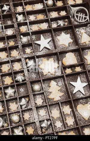 Hausgemachte Weihnachtsplätzchen, Sterne und Christbaumkugeln in alten hölzernen typecase Stockfoto