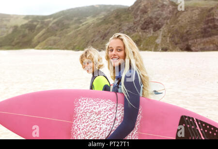 Spanien, Aviles, Porträt von zwei lächelnde junge Surfer am Strand Stockfoto