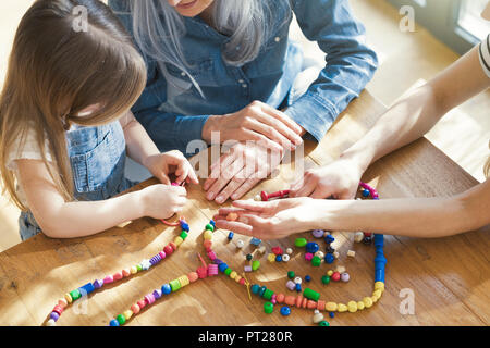 Großmutter und Enkelin und Mutter Gewinde Perlen Stockfoto