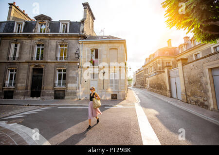 Blick auf die Straße mit schönen, alten Gebäuden und Frau wandern in Reims, Frankreich Stockfoto