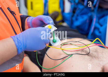 Notarzt Hände, das Anbringen der EKG-Elektroden auf der Brust des Patienten in der Ambulanz Stockfoto