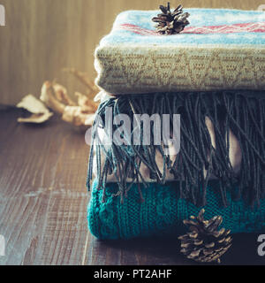 Stapel der warme und weiche Pullover auf Holzbrett. Herbst Konzept. Close Up. Stockfoto