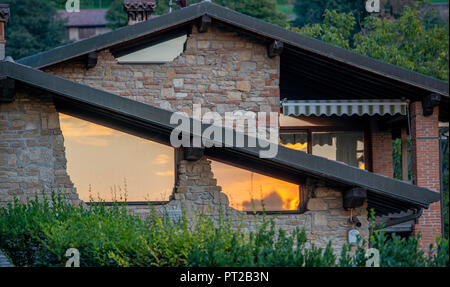 Renoviertes Haus eine Sonne in den Fenstern reflektierende Stockfoto