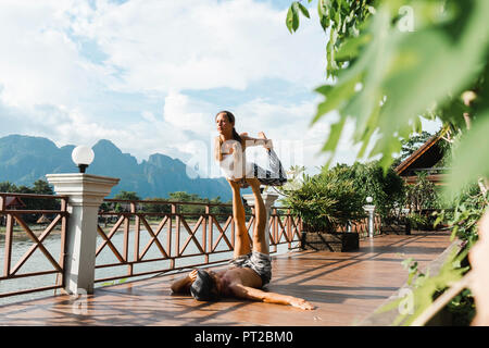 Laos, Vang Vieng, junges Paar acro tun - Yoga auf der Terrasse Stockfoto