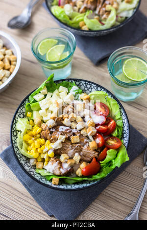 Schüssel mit Caesar Salat mit Fleisch, Mais und Tomaten/Paradeiser Stockfoto