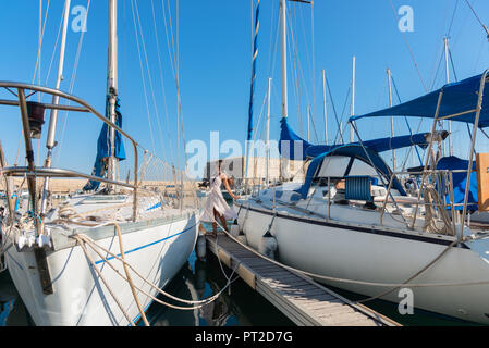 Elegante junge touristische Besucher Frau gehen auf eine Besichtigungstour am Venezianischen Hafen von Heraklion, Kreta, Griechenland. Die venezianische Festung Rocca eine Stute oder "KOULE" im Hintergrund Stockfoto