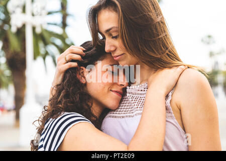 Zwei weibliche Freunde umarmen und umarmt im Freien Stockfoto