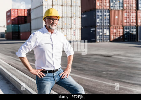 Unternehmer im Cargo Hafen, das Tragen von Helm, Porträt Stockfoto