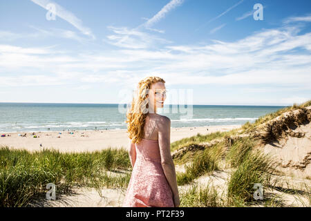 Niederlande, Zandvoort, Portrait von lächelnden Frau, die in den Dünen Stockfoto