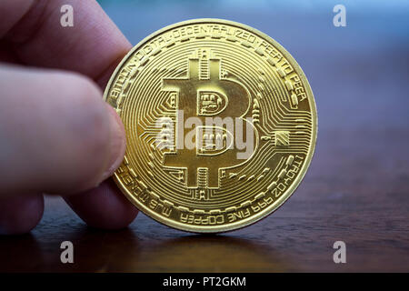 Hand mit einem Goldenen bitcoin. Virtuelles Geld, digitale Währung. Stockfoto