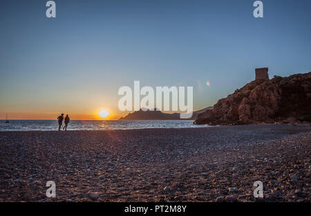 2 Personen am Strand vor der atmosphärischen Sonnenuntergang Stockfoto