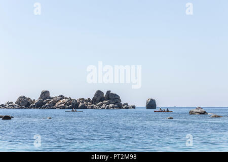 Aussicht auf die felsige Insel mit Kanus vor der Küste von Korsika Stockfoto