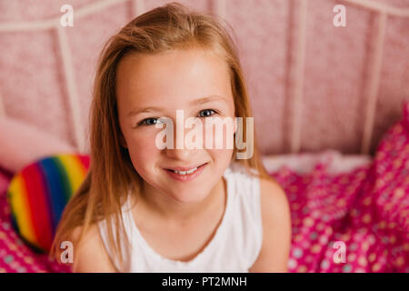 Portrait von lächelnden Mädchen im Schlafzimmer Stockfoto