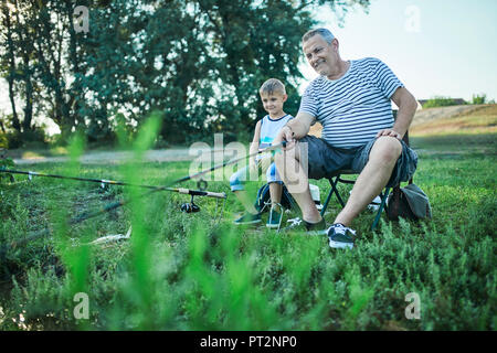 Großvater und Enkel Angeln zusammen am Seeufer Stockfoto