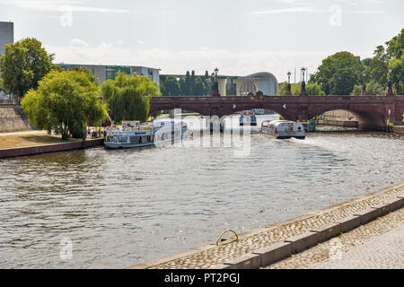 BERLIN, DEUTSCHLAND - 13. JULI 2018: Touristische Schiffe fahren entlang der Spree mit Moltke Brücke in der Nähe der Hauptbahnhof Central Railway Station. Spree fl Stockfoto