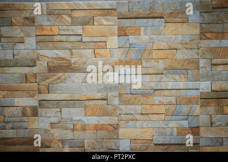 Wandfliesen wie natürliche split Stein gemusterten Hintergrund. Simulierte gelb Natursteinfassade, Wandfliesen Textur. Stockfoto