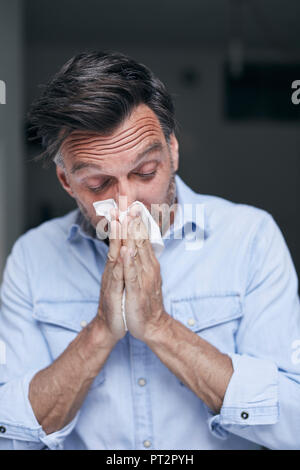 Portrait von Mann blasen Nase Stockfoto