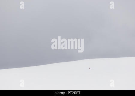 Ein sehr minimalistisches Blick auf zwei weit entfernte Menschen über einen Berg von Schnee bedeckt Stockfoto