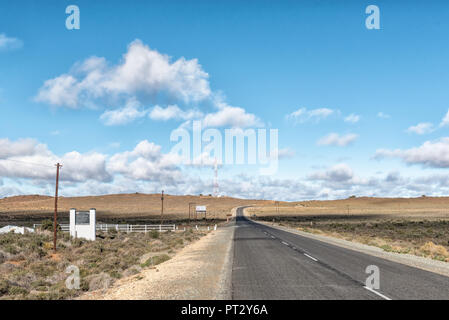 LOXTON, SÜDAFRIKA, 7. AUGUST 2018: Landschaft auf der Straße R63 in der Nähe von Loxton in der Northern Cape Provinz. Name Boards und ein Handy Turm sichtbar sind Stockfoto
