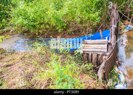 Native Thai Fischfalle aus gewebten Bambus mit blauem Nylon net installiert ist, um den Stream zu behindern laichenden Fische zu fangen, in der Regenzeit. Stockfoto