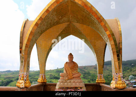 Smiling Buddha auf einer der Ebenen von Pha Kaew Sorn unter einer goldenen Kuppel, die in der Pha Sorn Kaew, in Khao Kor, Phetchabun, Thailand. Stockfoto