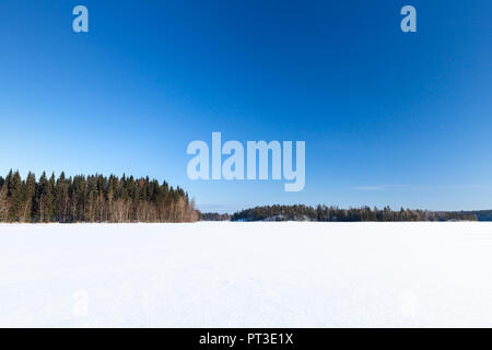 Gefrorenen See unter tief blauen Himmel. Ländliche Winterlandschaft, Finnland Stockfoto