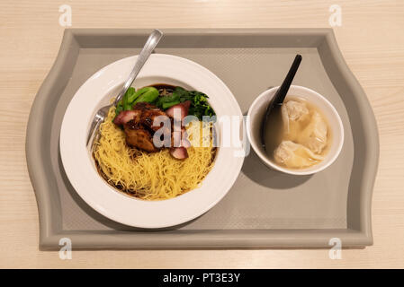 „Trockene“ Wantonnudeln in Singapur bestehen aus einem Teller Nudeln in Sauce mit gegrilltem Schweinefleisch und Gemüse. Die Wantonknödel werden in Suppe serviert. Stockfoto