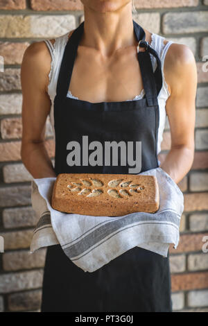 Frau Baker Holding frisches hausgemachtes Brot. Stockfoto