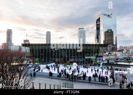 Eisbahn, die während der Weihnachtszeit außerhalb des Umekita Schiff Halle Teil des Grand vorne Osaka Komplex gesetzt wird. Umeda Sky Building im Hintergrund. Stockfoto