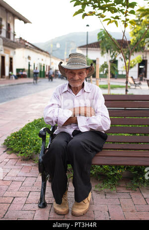 Ältere Latino Mann sitzt auf der Bank das Tragen der traditionellen sombrero vueltiao Hut. Santa Fe de Antioquia, Kolumbien. Redaktionelle Verwendung. Sep 2018 Stockfoto