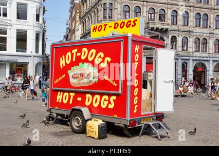 Eine rote geschlossen Hot Dog Stand mit der Hintertür offen, von Tauben und Touristen in der Dam Platz, Amsterdam, Niederlande umgeben Stockfoto