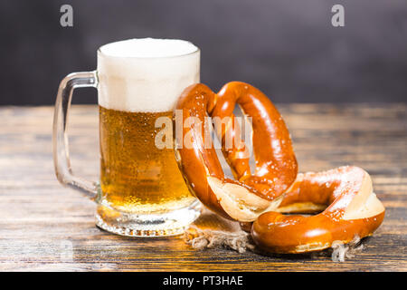 Essen und Getränke Konzept - ein Glas Bier und Bagels auf Holz Tisch Stockfoto