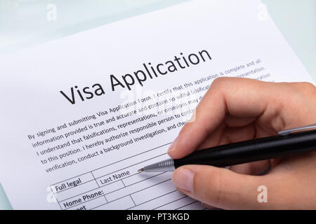 Nahaufnahme von einer Frau Hand Befüllen Visumsantrag mit Stift Stockfoto