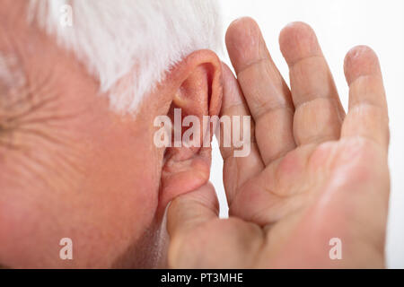 Portrait eines älteren Mannes Hand versucht nach dem Einlegen Hörgerät zu hören Stockfoto